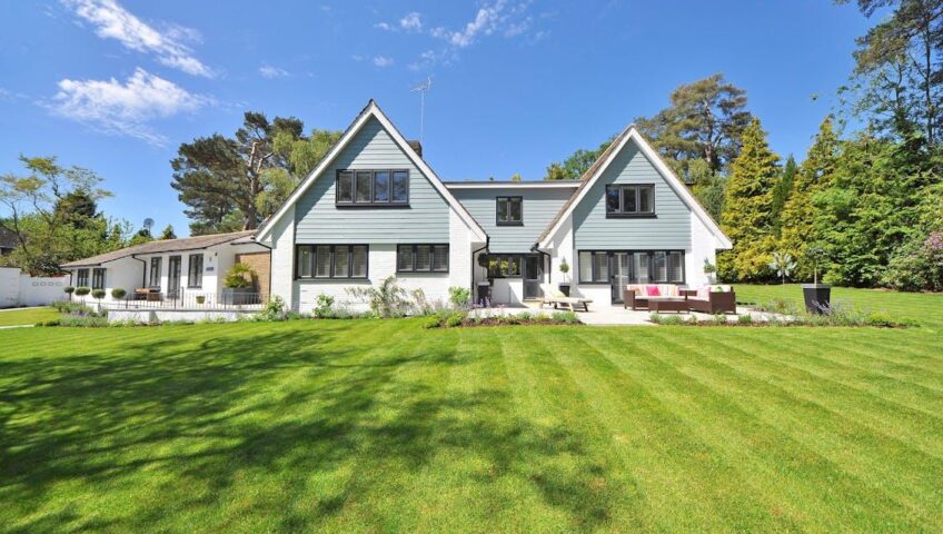 : A well-maintained front yard with trimmed grass, shrubs, and flowers in front of a home.